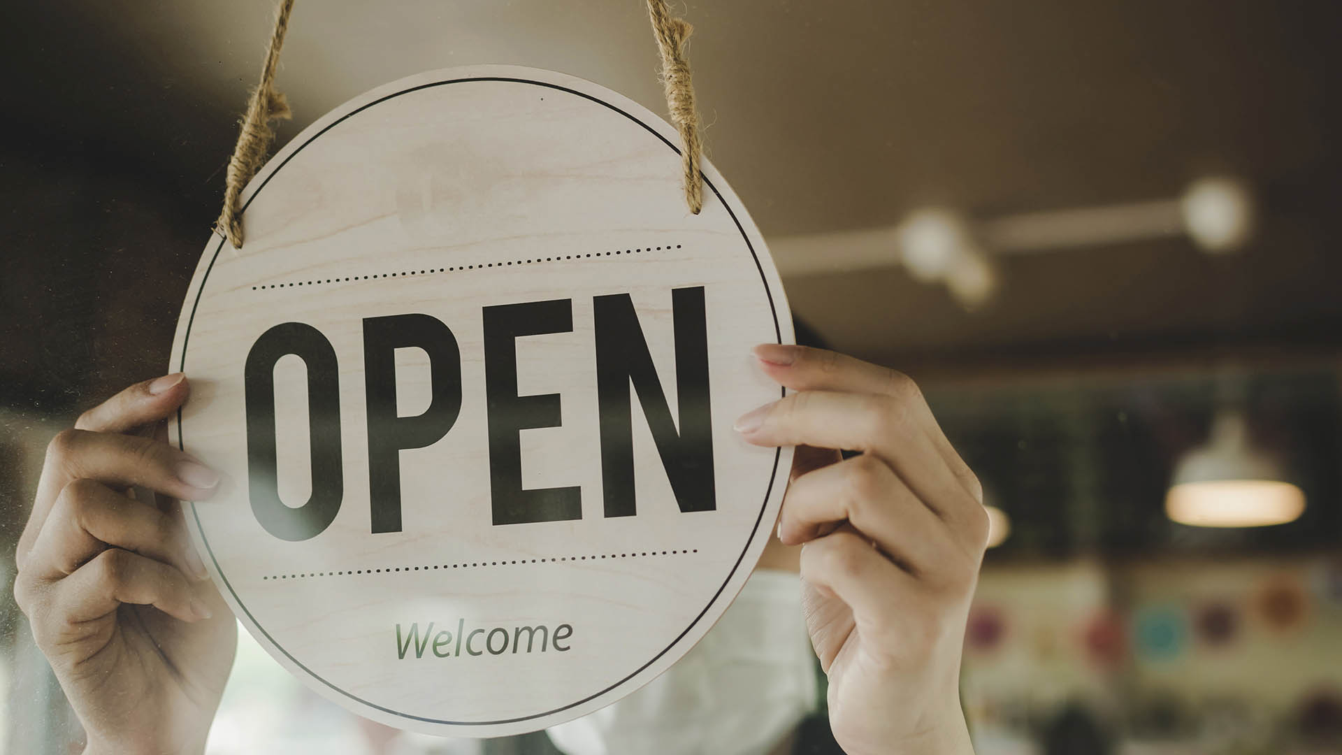 barista, waitress woman wearing protection face mask turning open sign board on glass door in modern cafe coffee shop, cafe restaurant, retail store, small business owner, food and drink concept