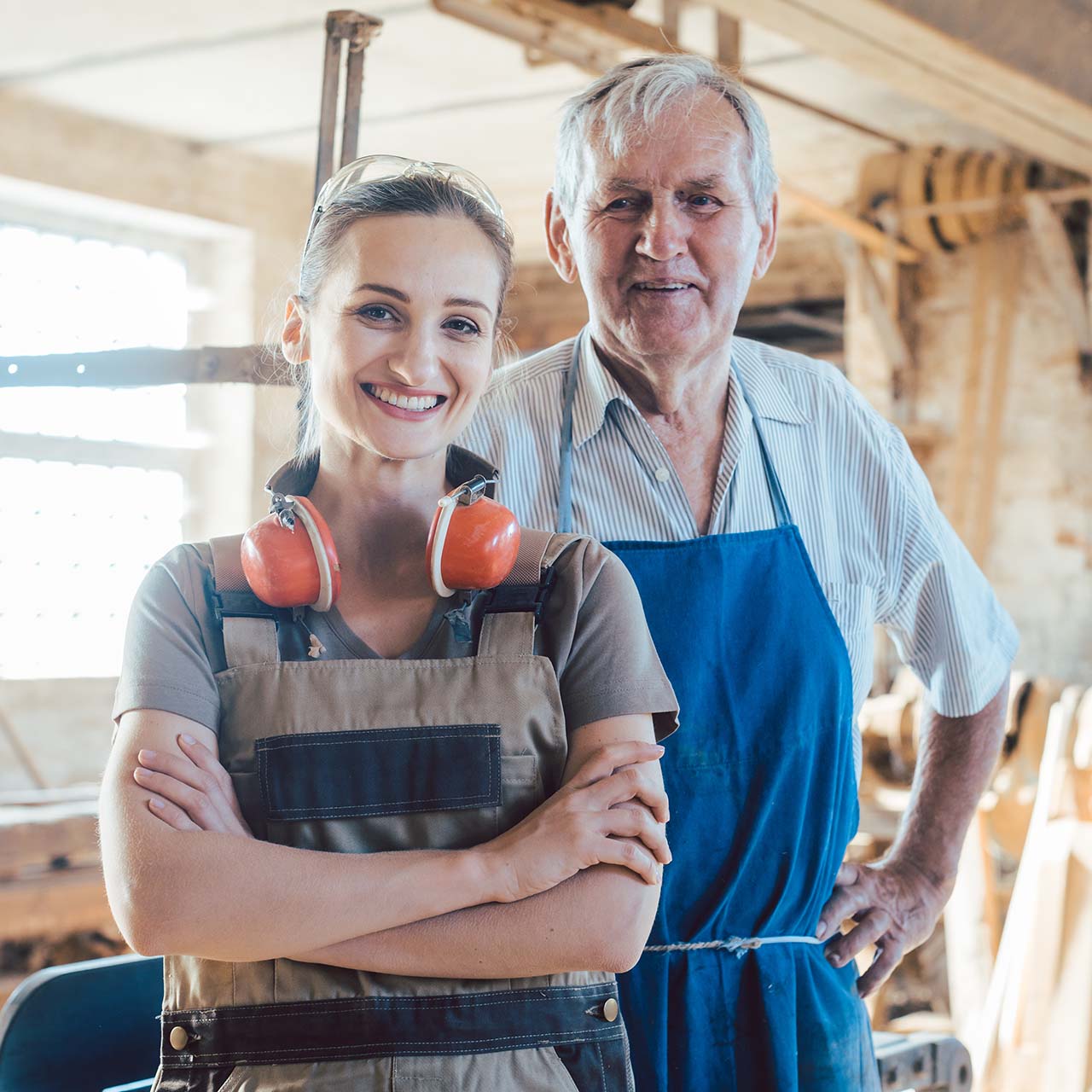 Senior master carpenter with his granddaughter in the wood works